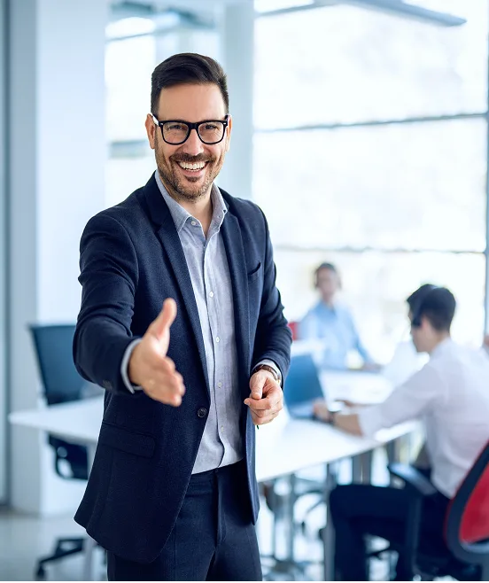 Businessman welcoming new employee to his business team and company in a modern office.