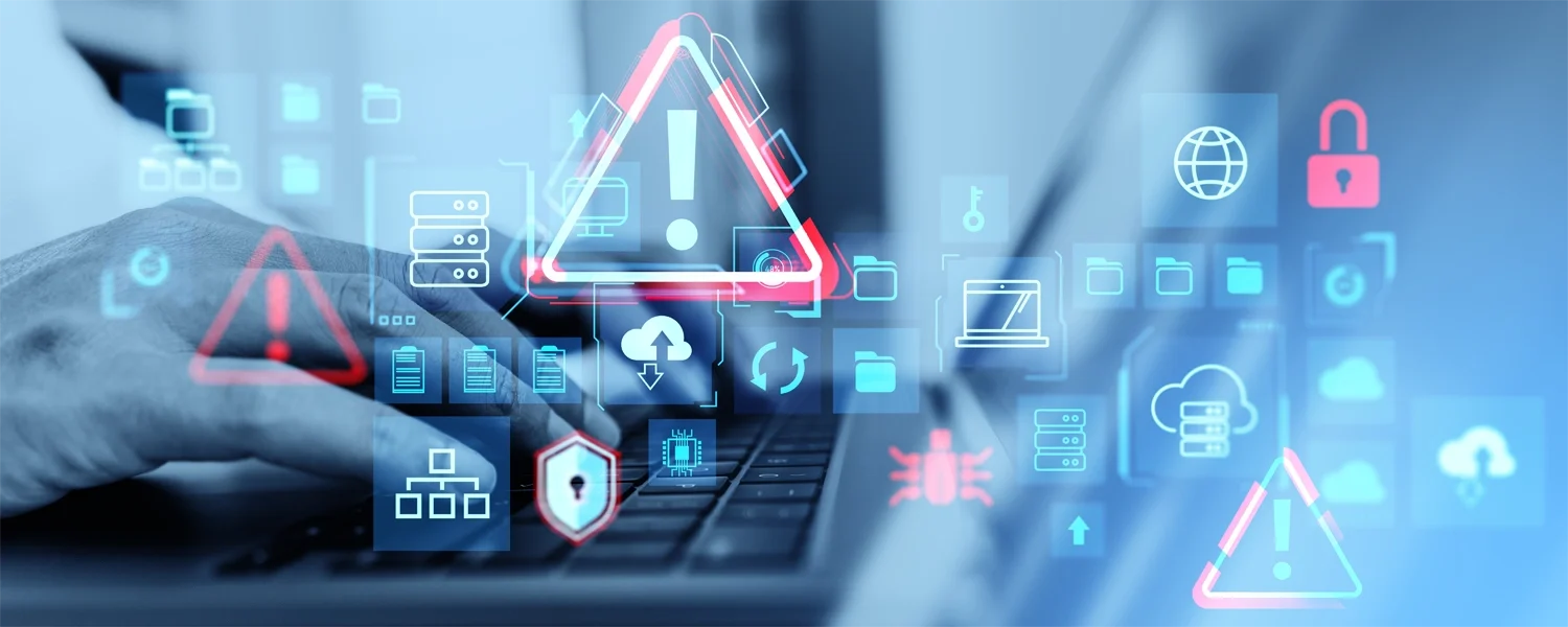 Alert icons and cybersecurity warnings overlay a person working on a computer, with prominent red warning triangles and messages about malware, ransomware, and digital security.
